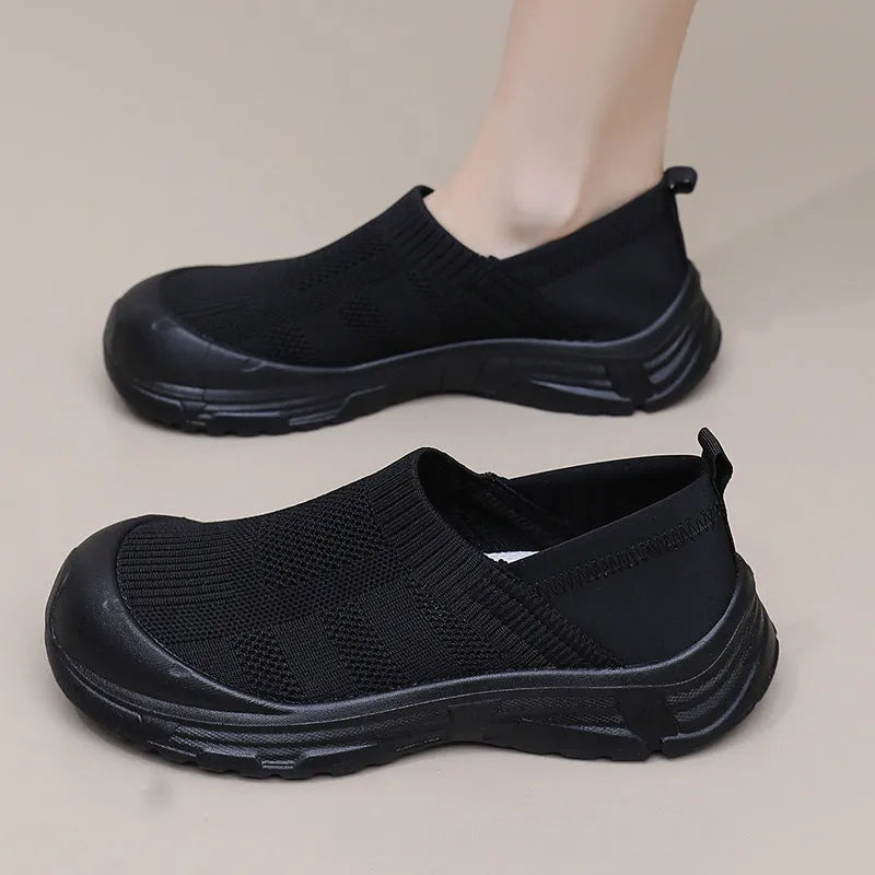 Women's black slip-on shoes with cloth upper and PVC sole showing one pedal design