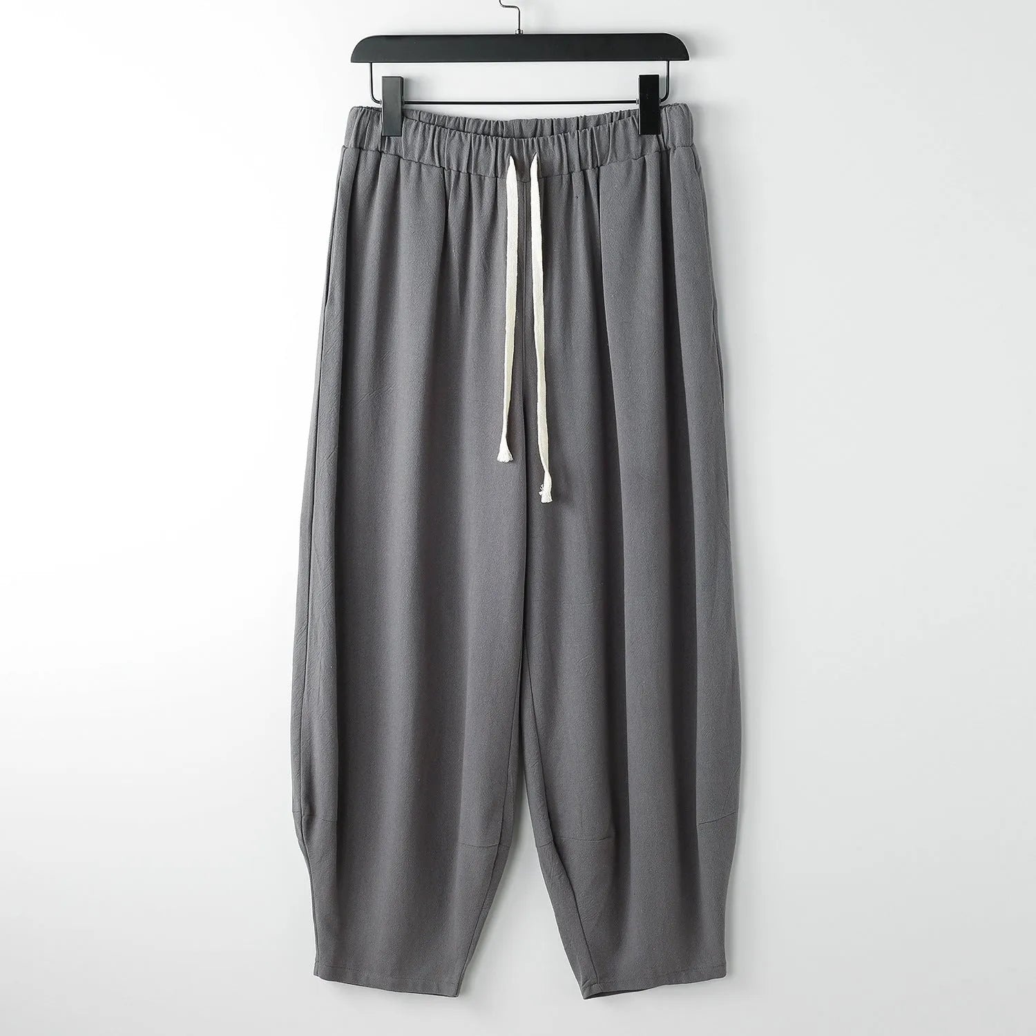 Men's linen harem pants with ankle ties in tapered loose fit on larger model