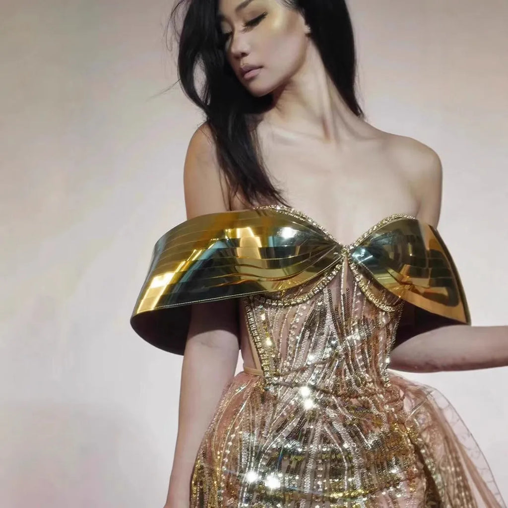 Gold metallic strapless dress with sequin details and a full tulle skirt featuring a high split.