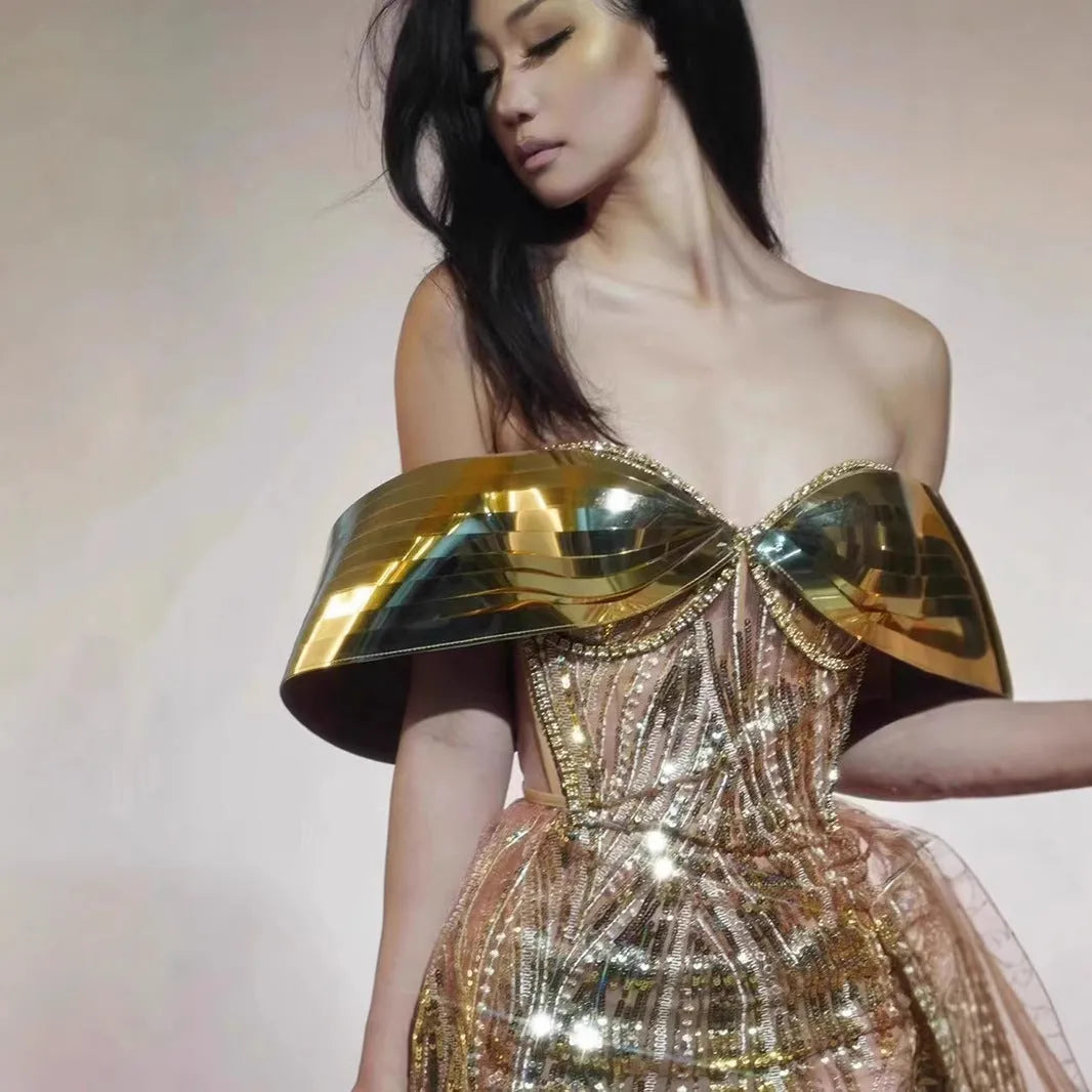 Gold metallic strapless dress with sequin details and a full tulle skirt featuring a high split.
