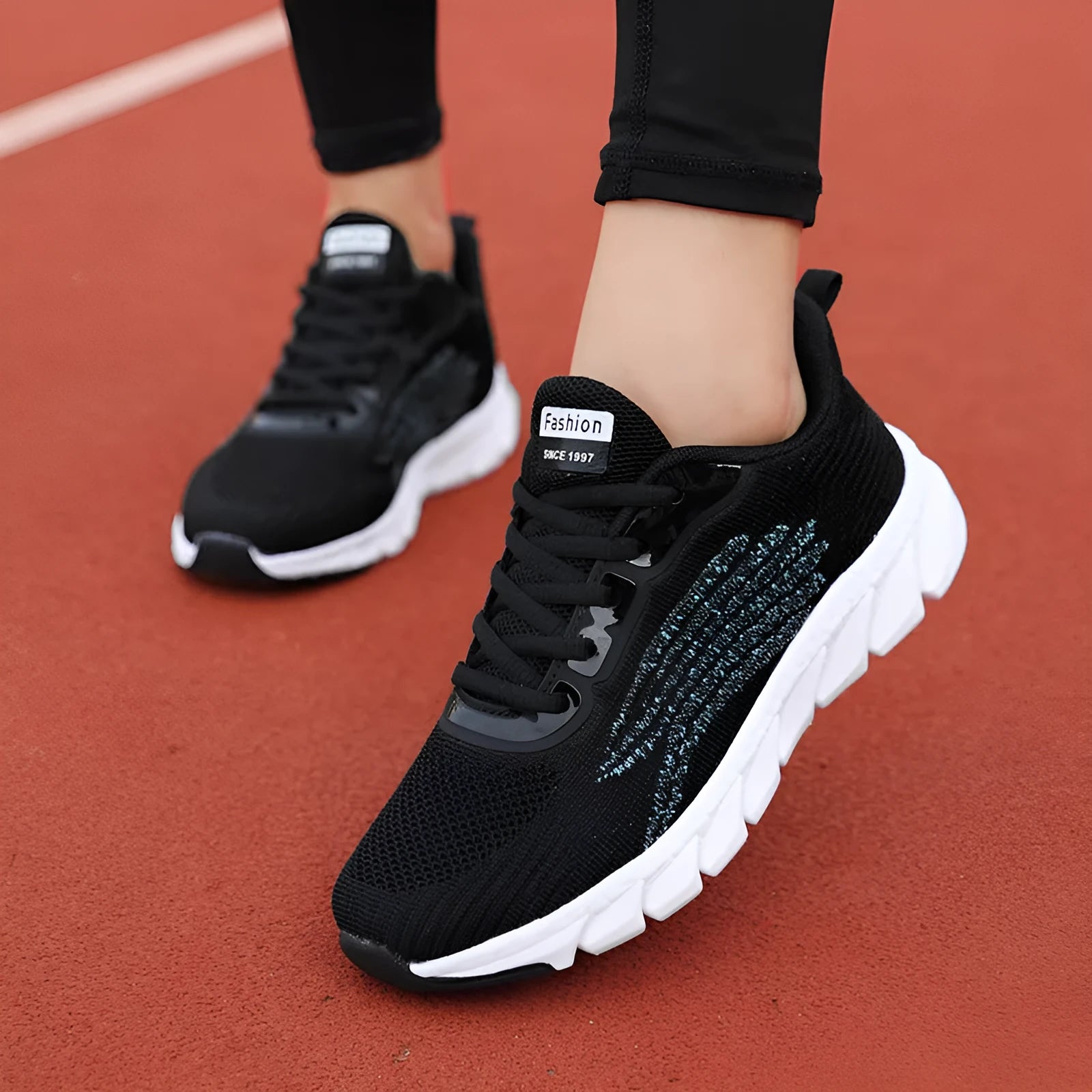 Women's low-top platform running sneakers in black and white colours with round toe and cross strap design