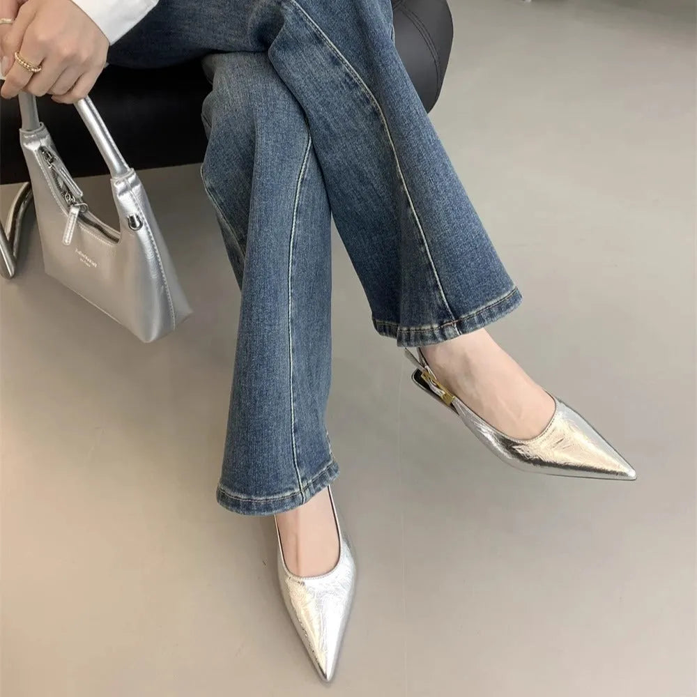 Women's black leather pointed-toe shoes with a thin low heel and an ankle strap.