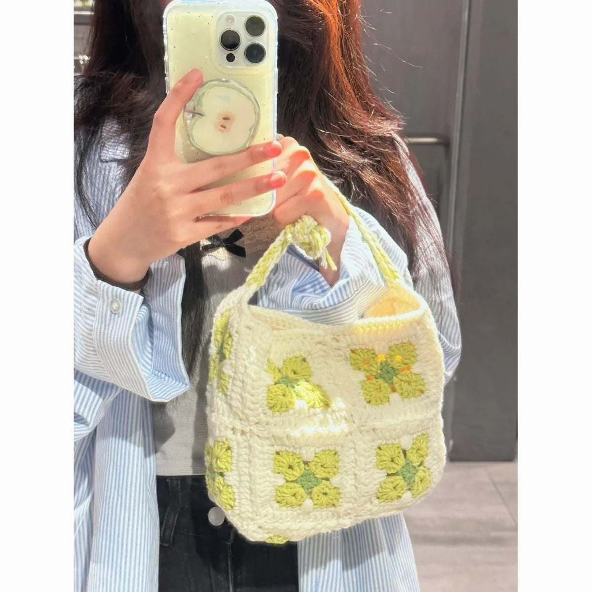 Handmade pink crochet handbag with cherry blossom design and magnetic buckle.