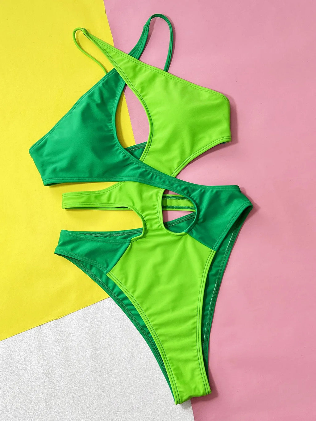 Green women's one-piece swimsuit with hollow contrast colour design on mannequin