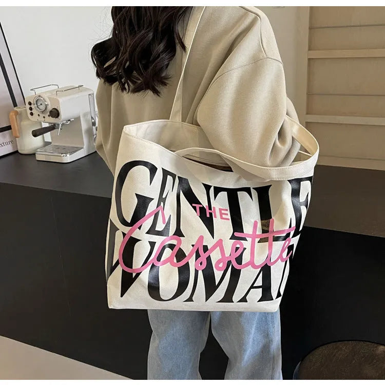 Letter printed canvas tote bag in off white with car stitching detail and top handles