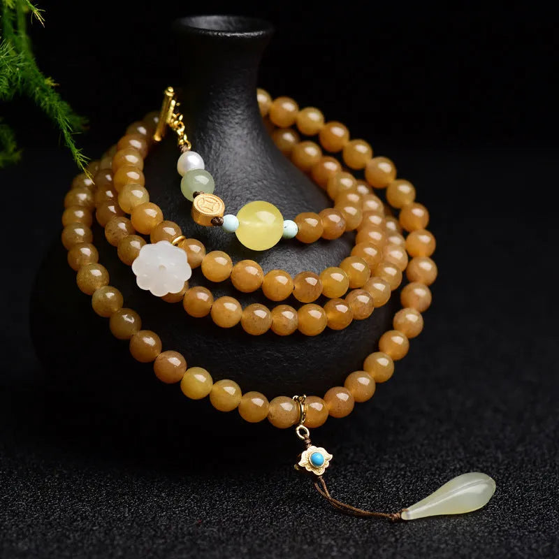 Close-up of a green jade bead bracelet with leaf sequins and a beeswax sheen.