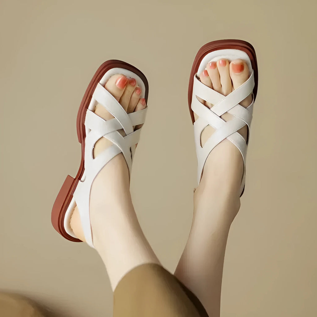 Women's glossy black patent leather beach sandals with a square toe and cross-belt design on a rubber sole.