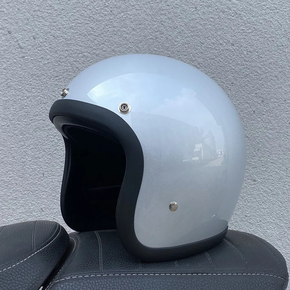 A retro-style grey half helmet for motorcycle riding, shown on a stand.