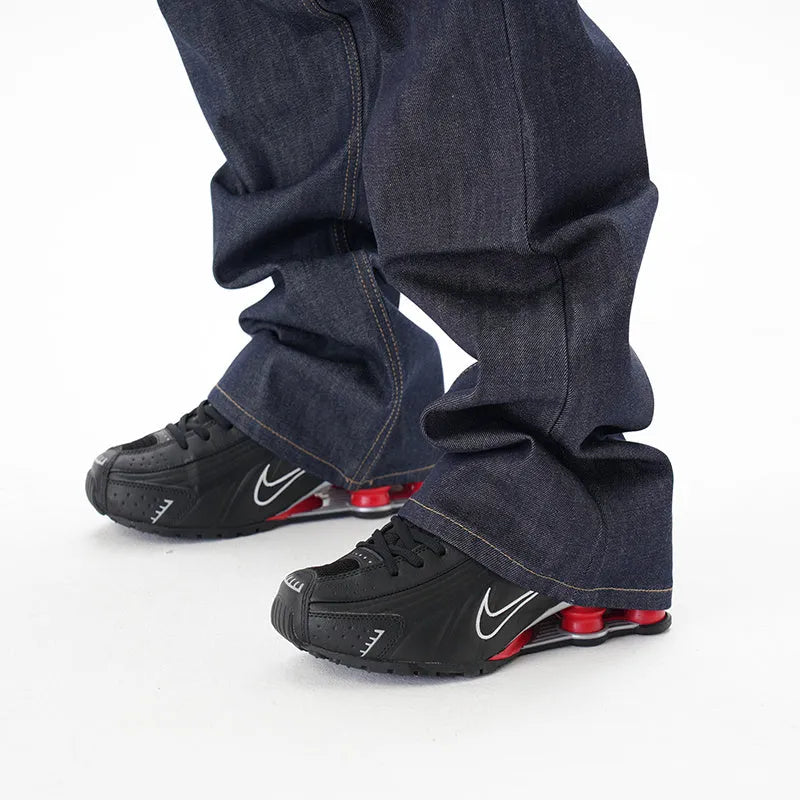 Man's dark blue loose-fit straight leg denim jeans on a neutral background.