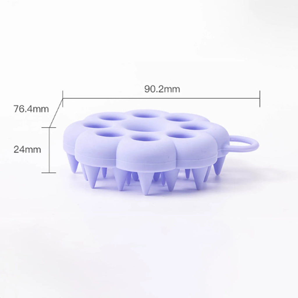 Blue silicone pet grooming brush with soft bristles and an ergonomic massage handle on a white background.