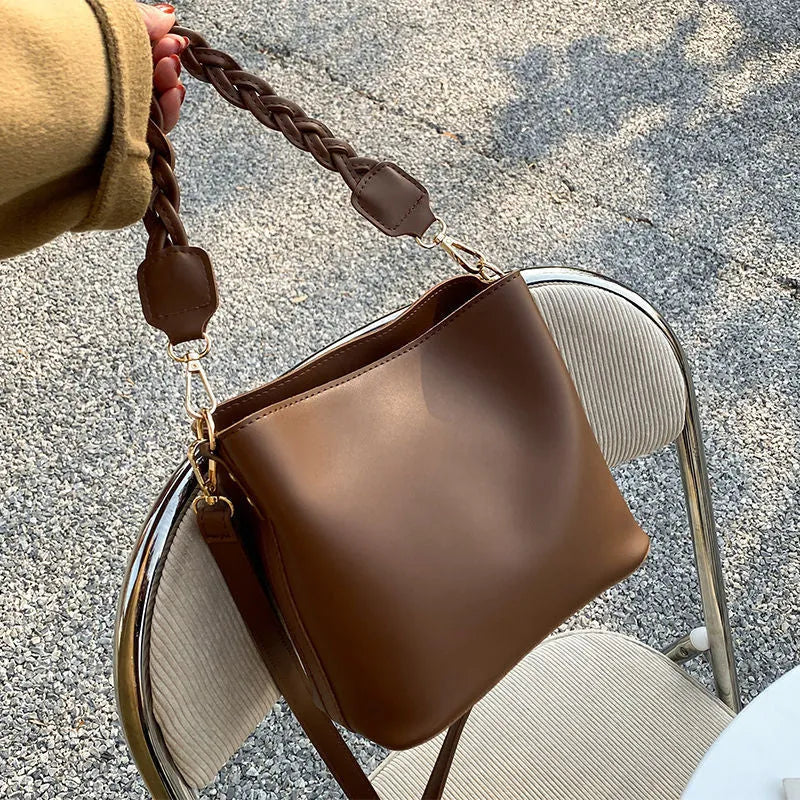 Retro woven PU leather bucket bag in khaki colour with crossbody strap.