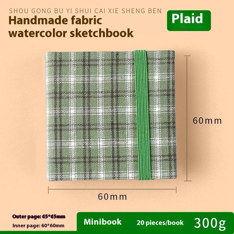 Feiluniao handmade fabric watercolour notebook with illustrated cover, open to show blank paper pages.