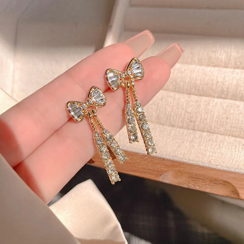 Gold butterfly earrings with rhinestones and bow element on alloy base