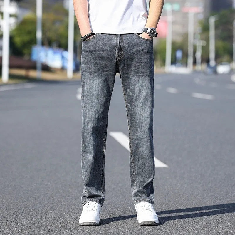 A pair of tapered fit stretch denim trousers in a light blue colour, laid flat.