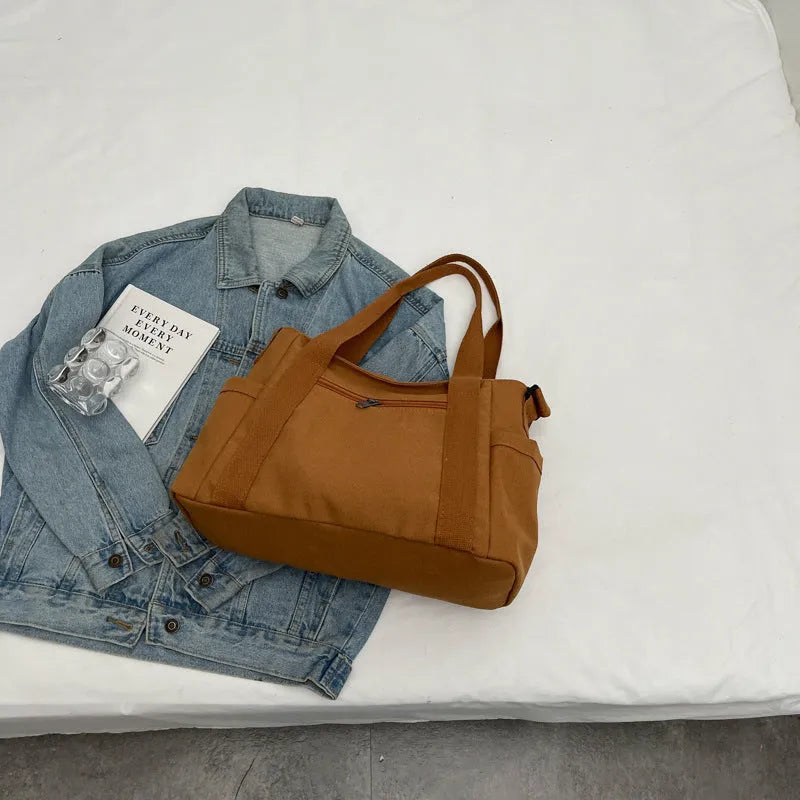Large capacity polyester canvas shoulder tote bag in a solid colour, showing outer sandwich pocket.