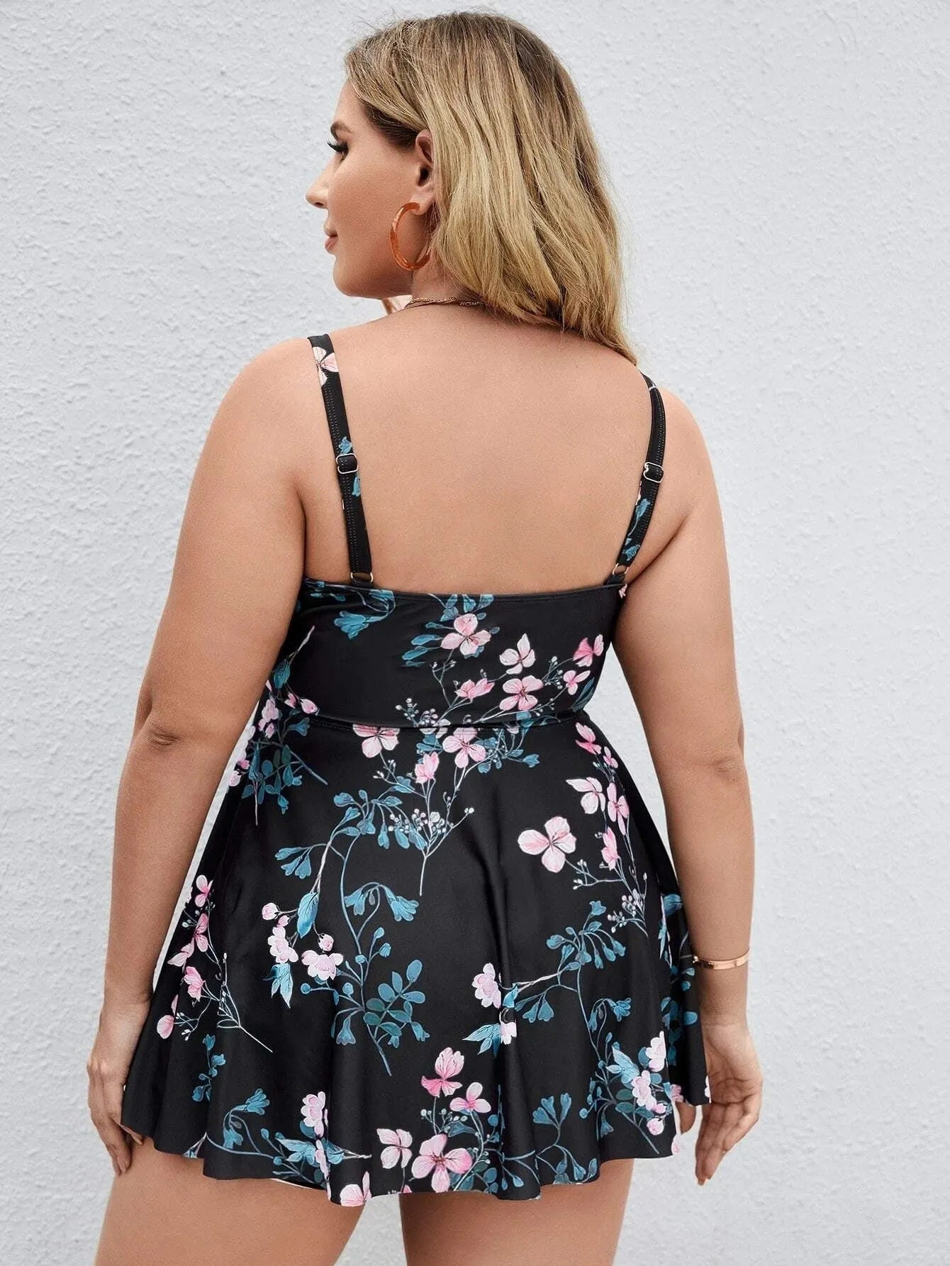 Women's one-piece swimsuit with a split colour floral pattern, shown on a model.