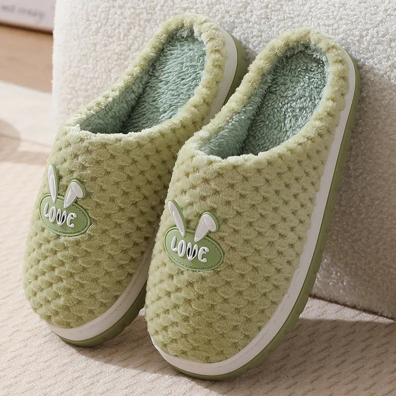 A pair of plush artificial fur house slippers with a baotou toe and a flat rubber sole, shown in a choice of colours.