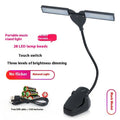 Rechargeable 28-LED music stand lamp in black plastic on a music stand with USB cable