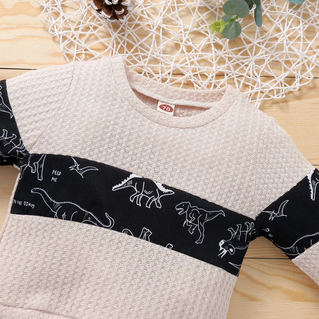 Cotton children's pants suit with dinosaur cartoon pattern in beige, pullover top and trousers set on child model