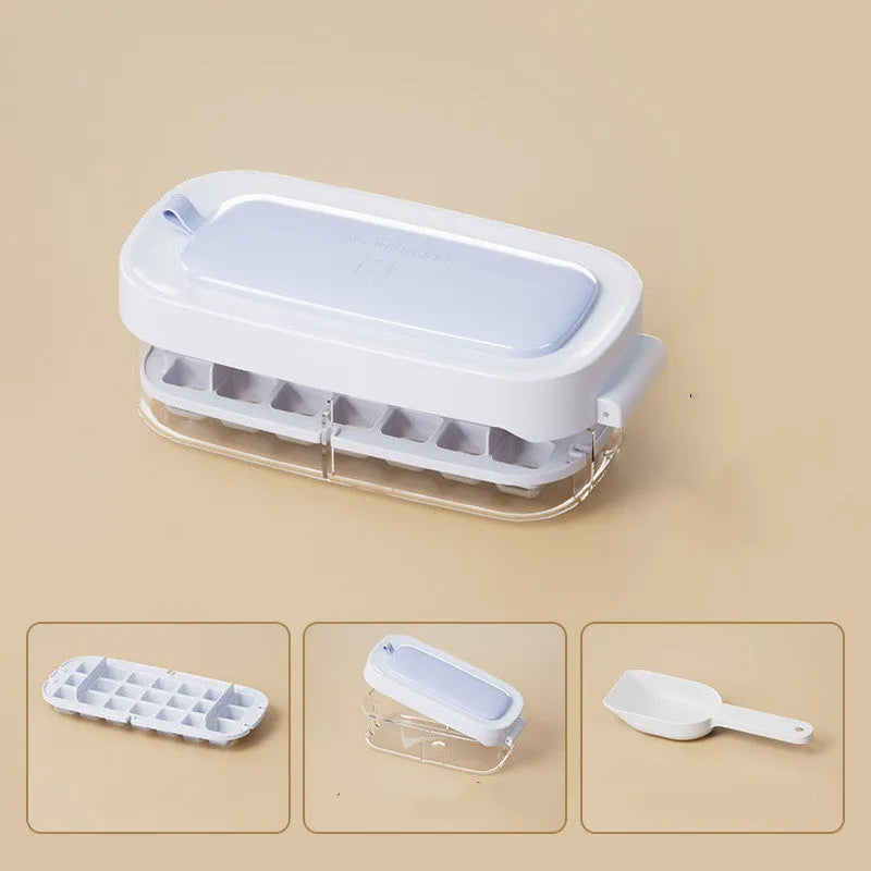 Yellow lever-action ice cube tray with high-capacity grid and attached ice shovel on a blue background.