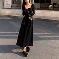 Black square collar knitted A-line dress with elastic waist and long sleeves on a model