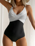 Women's lace-up backless one-piece swimsuit in floral print on mannequin, showing adjustable back detail.