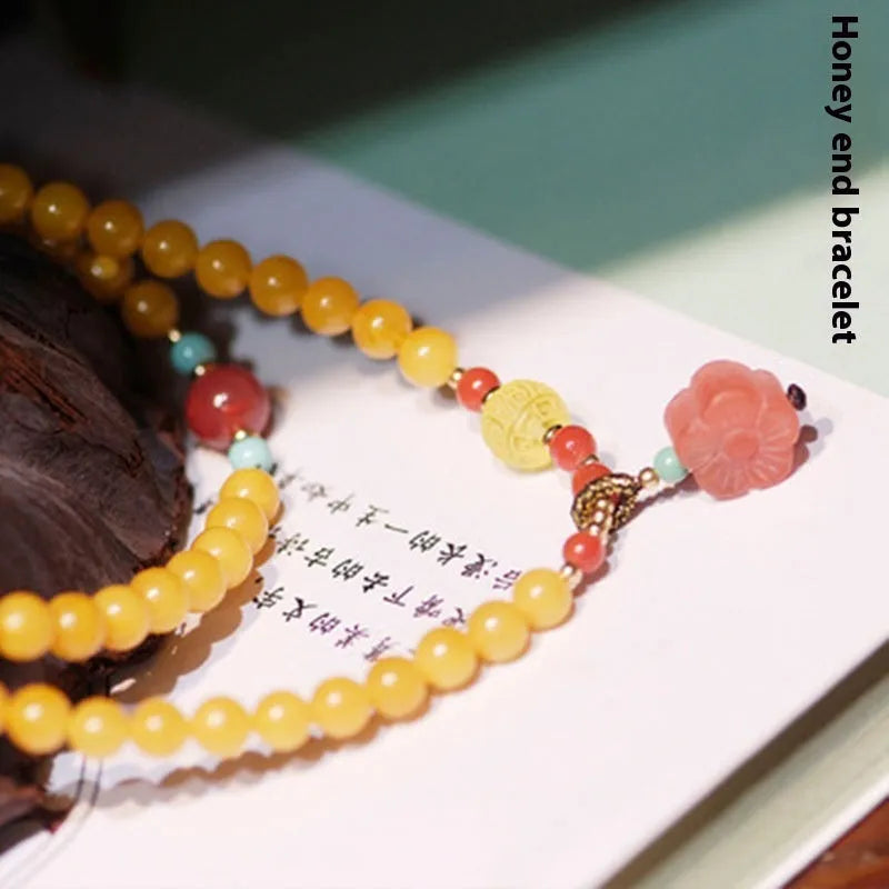 Yellow amber bracelet with 5mm round beads and animal zodiac design on a wrist.