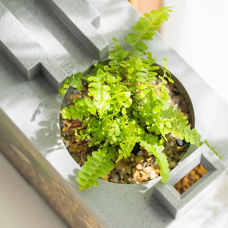 Small stone trough plastic fish tank with water pump and built-in light on a desk