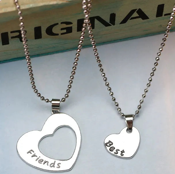 Two silver alloy heart-shaped puzzle necklaces on cross chains, matching set
