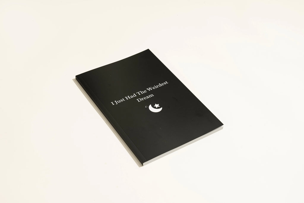 Black Dream Journal notebook with a business-simplicity design, open on a surface.