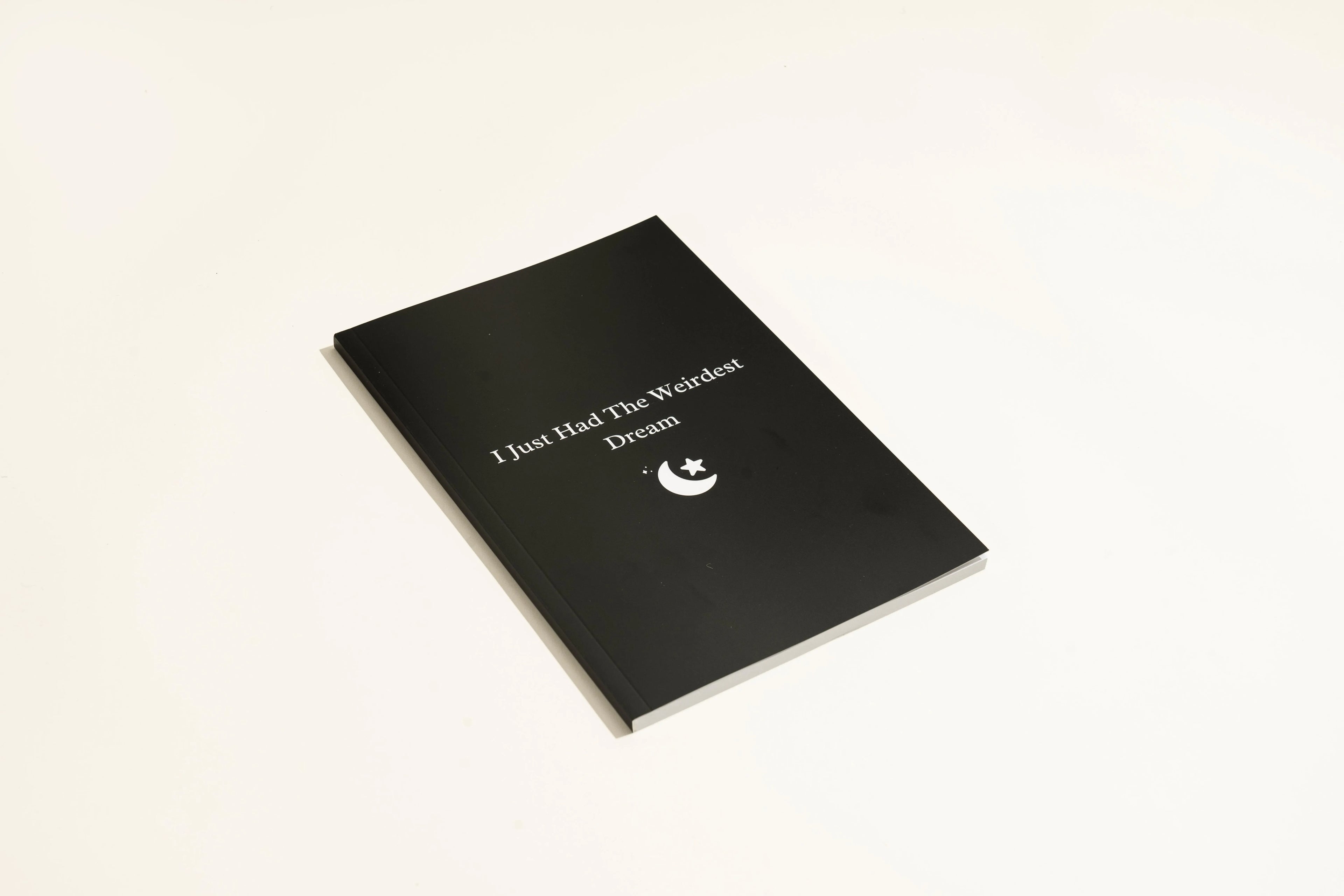 Black Dream Journal notebook with a business-simplicity design, open on a surface.