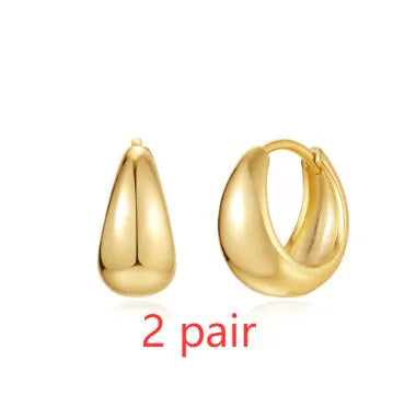 A pair of gold tone geometric earclip earrings with a round design and screw-back mechanism.