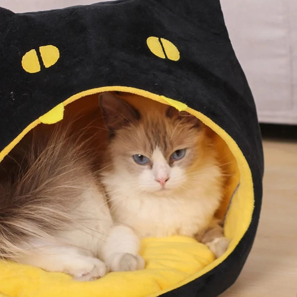 Grey cat-shaped covered pet bed with a removable cushion, shown on a wooden floor.