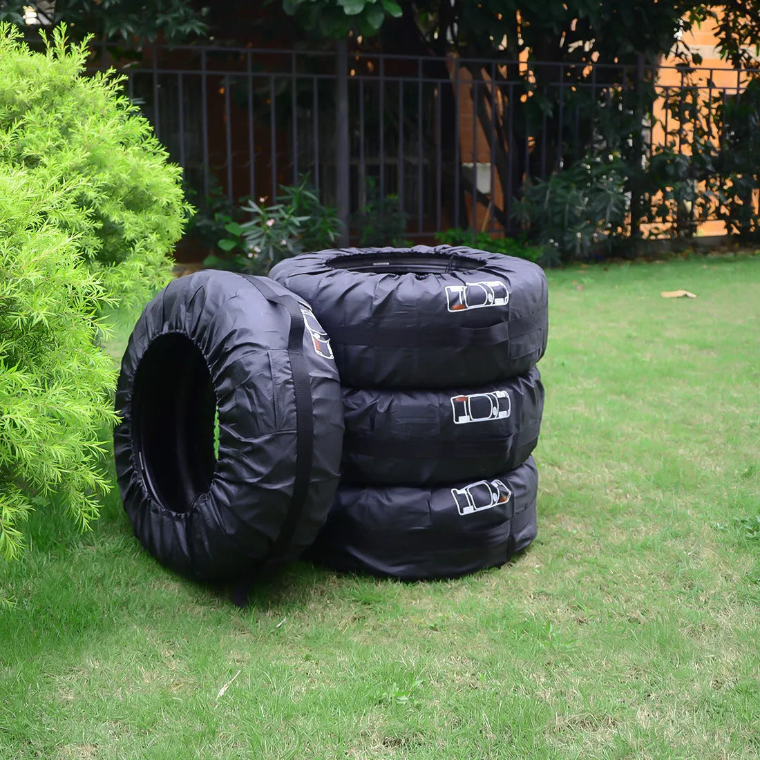 Set of four black Oxford cloth car tyre protective covers for parked vehicles.