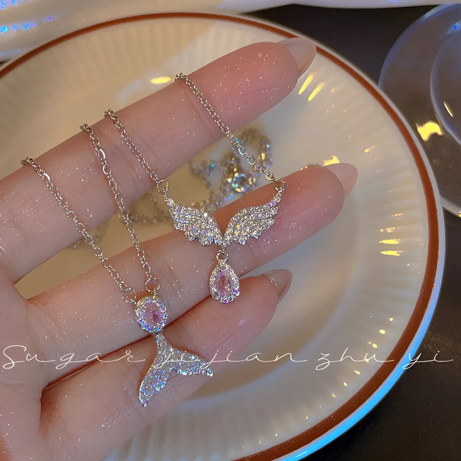 Women's sterling silver necklace showing Angel Wings and Fishtail pendant options on an adjustable O-ring chain.