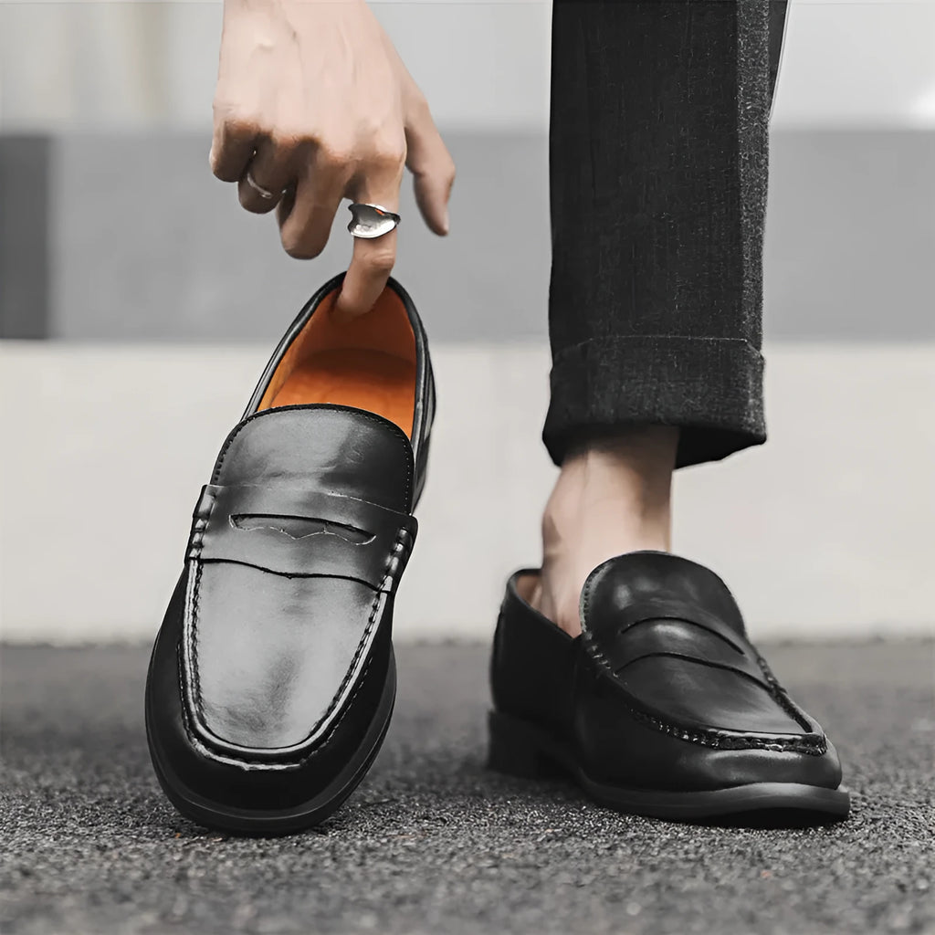 Men's black casual slip-on leather shoes with soft bottom and sewing line detail on a clean background