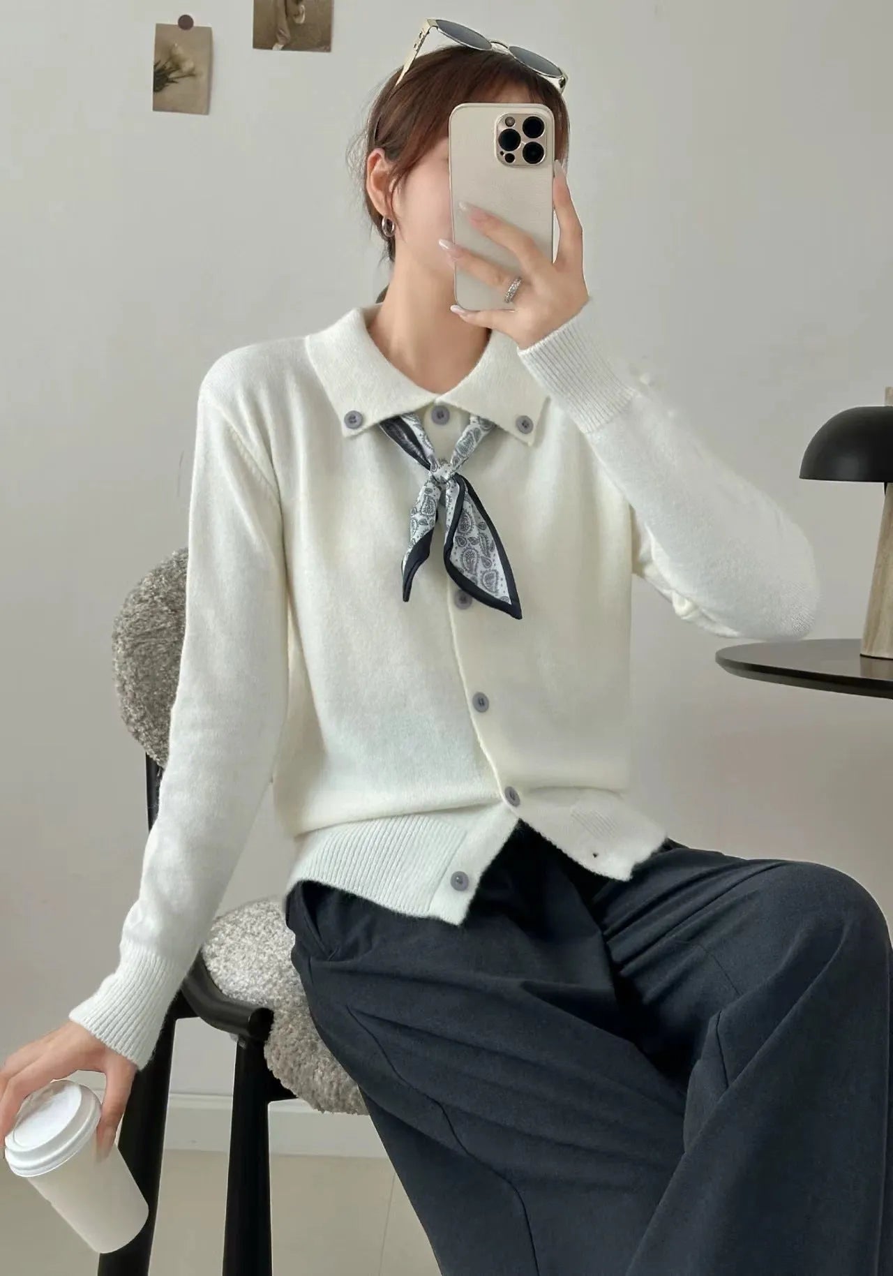 Milky white acrylic fibre cardigan sweater with a lapel scarf and long sleeves laid flat