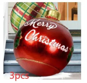 Large red and white striped inflatable Christmas ball ornament hanging on an outdoor tree