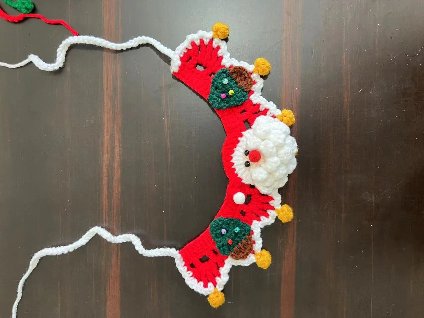 Knitted wool Christmas scarf for pets featuring festive patterns like striped Santa and elk, shown attached to a dog collar.
