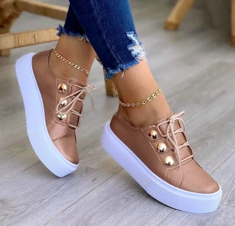 Women's white lace-up flats sneakers with round toe and silver rivet details on the low upper.