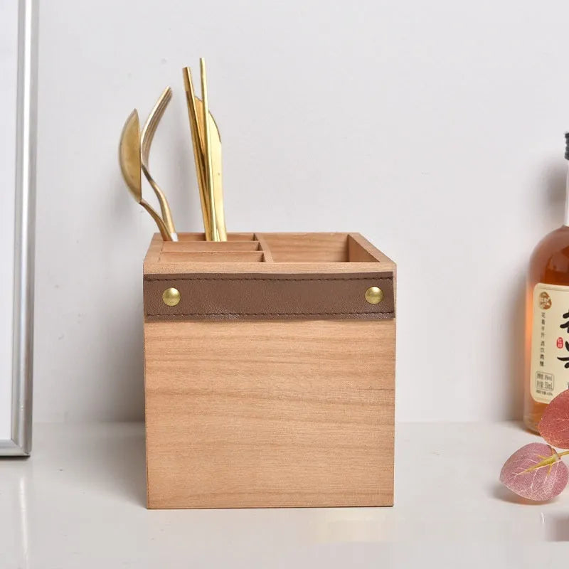 Open wooden kitchen storage box with grid divider for knives, forks, and chopsticks.