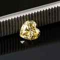 Lemon yellow heart-shaped moissanite gemstone showing symmetrical cut and warm colour