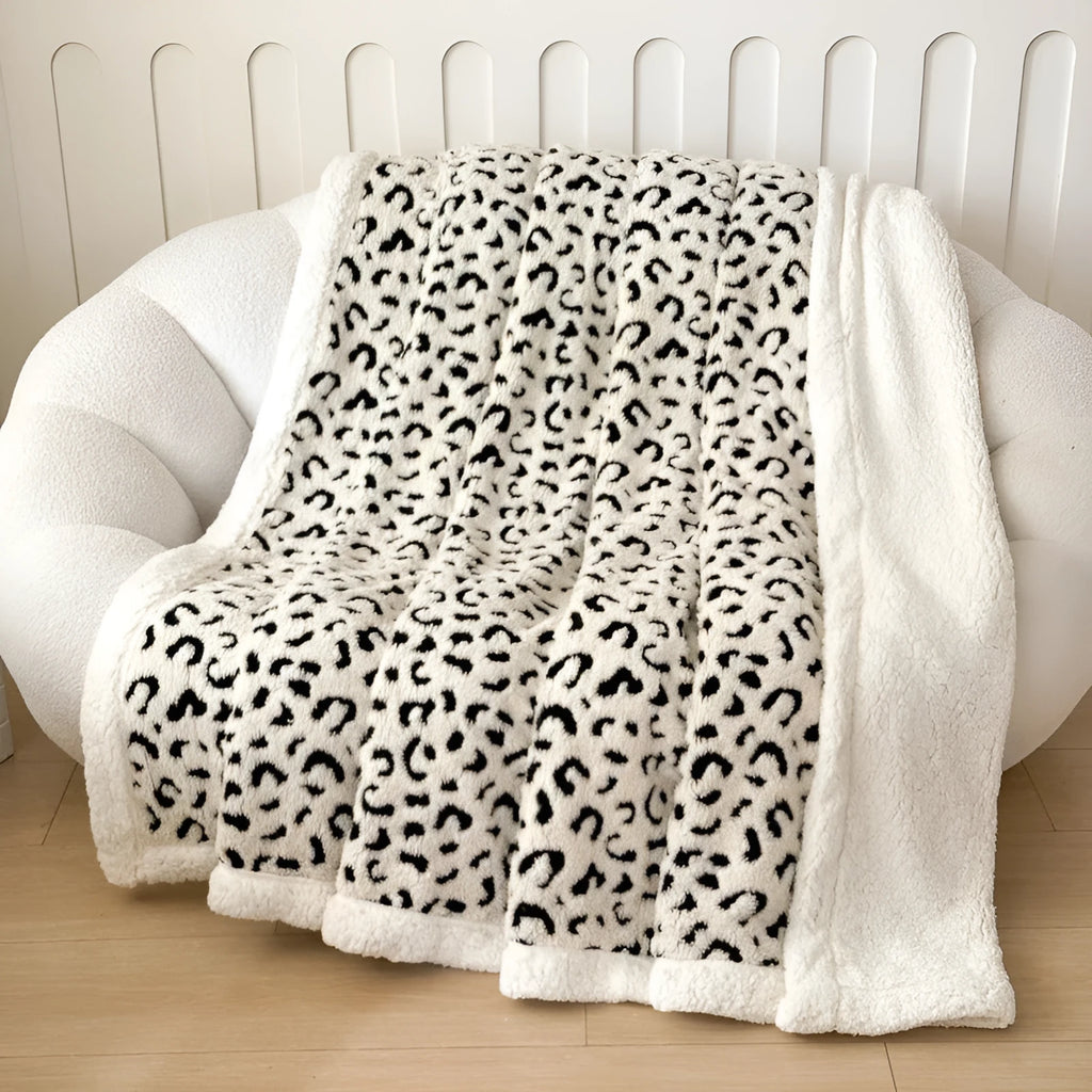 Double-layer taffeta blanket with woven leopard print pattern draped over sofa