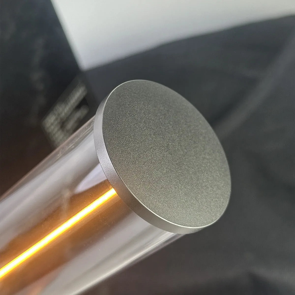 Tall cylindrical frosted glass USB rechargeable LED night light with a magnetic base on a wooden surface.