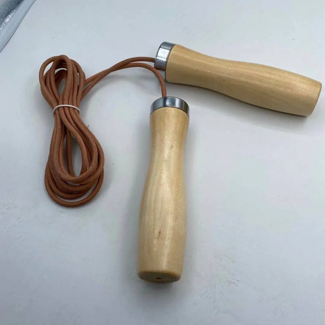 Real cowhide leather jump rope with solid wood handles and denim grip on grey background