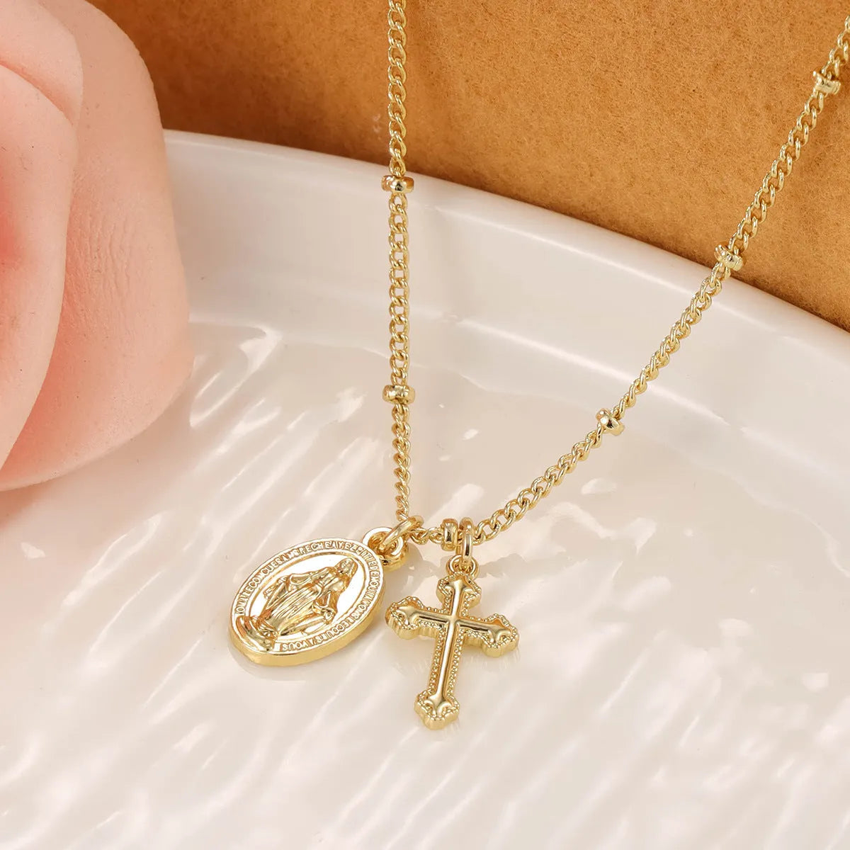 Geometric Virgin Mary cross pendant necklace in gold colour on a chain