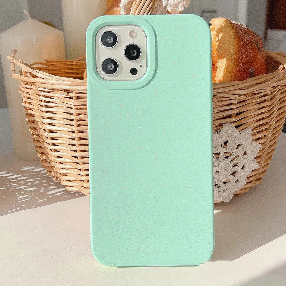 Degradable wheat straw phone case for Apple iPhone on a wooden surface.