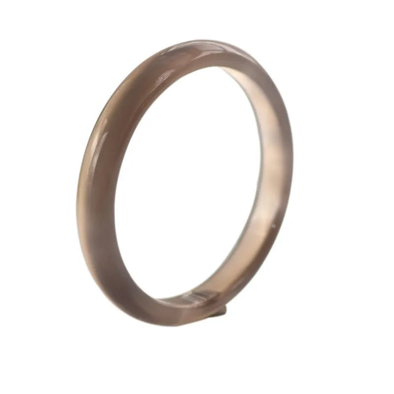 Women's dark grey agate bracelet in a circular design on a wrist.