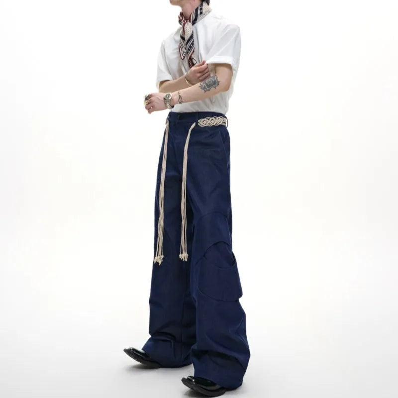Man wearing dark blue loose-fit straight-leg cotton jeans with zip decoration and belt stitching.