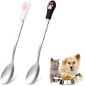 White and black pet food spoons with cat paw designs and silicone handles